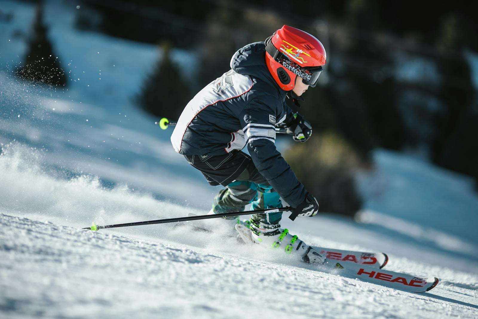Un skieur en mouvement portant des vêtements d'hiver, glissant rapidement sur une pente enneigée.